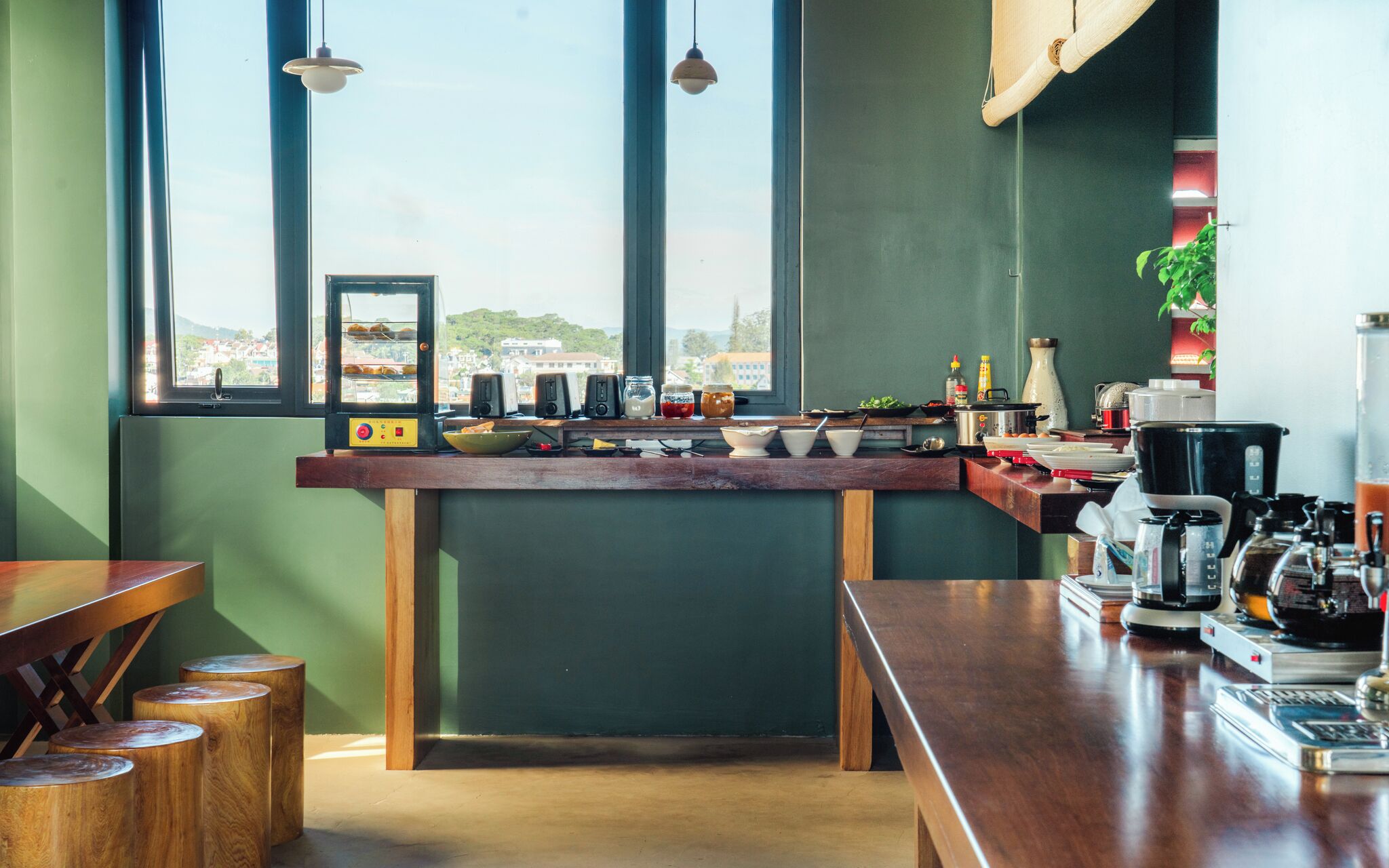 A modern kitchen with a view of a cityscape, equipped with a coffee machine, toaster, and various kitchen appliances.