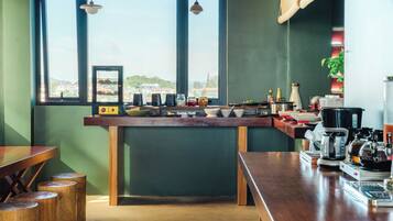 A modern kitchen with a view of a cityscape, equipped with a coffee machine, toaster, and various kitchen appliances.