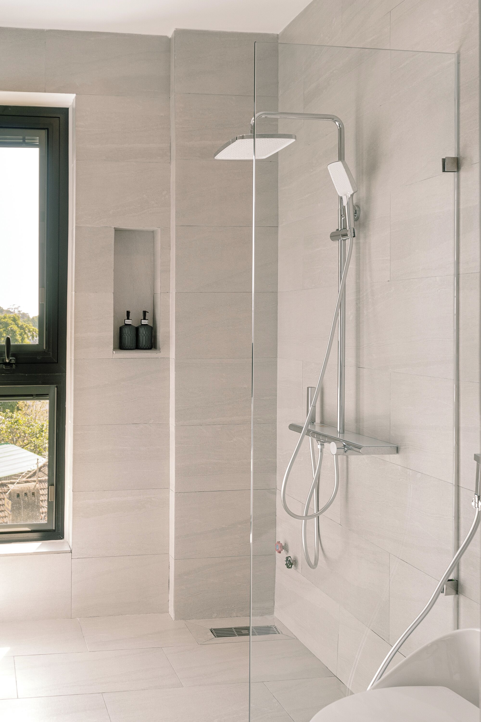 Un baño moderno con ducha de vidrio, inodoro y lavamanos.