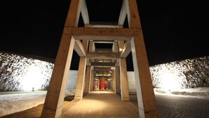 Une entrée moderne, caractérisée par une structure géométrique et une porte rouge.