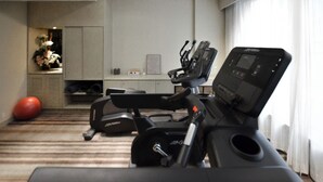 A home gym with exercise equipment, a red exercise ball, and a decorative vase with flowers. - Eco Tree Hotel Causeway Bay (Hong Kong)