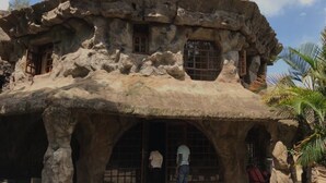 Una estructura rocosa con puertas y ventanas arqueadas, que sugiere un interior parecido a una cueva.