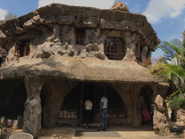 A rock-like structure with arched doorways and windows, suggesting a cave-like interior.