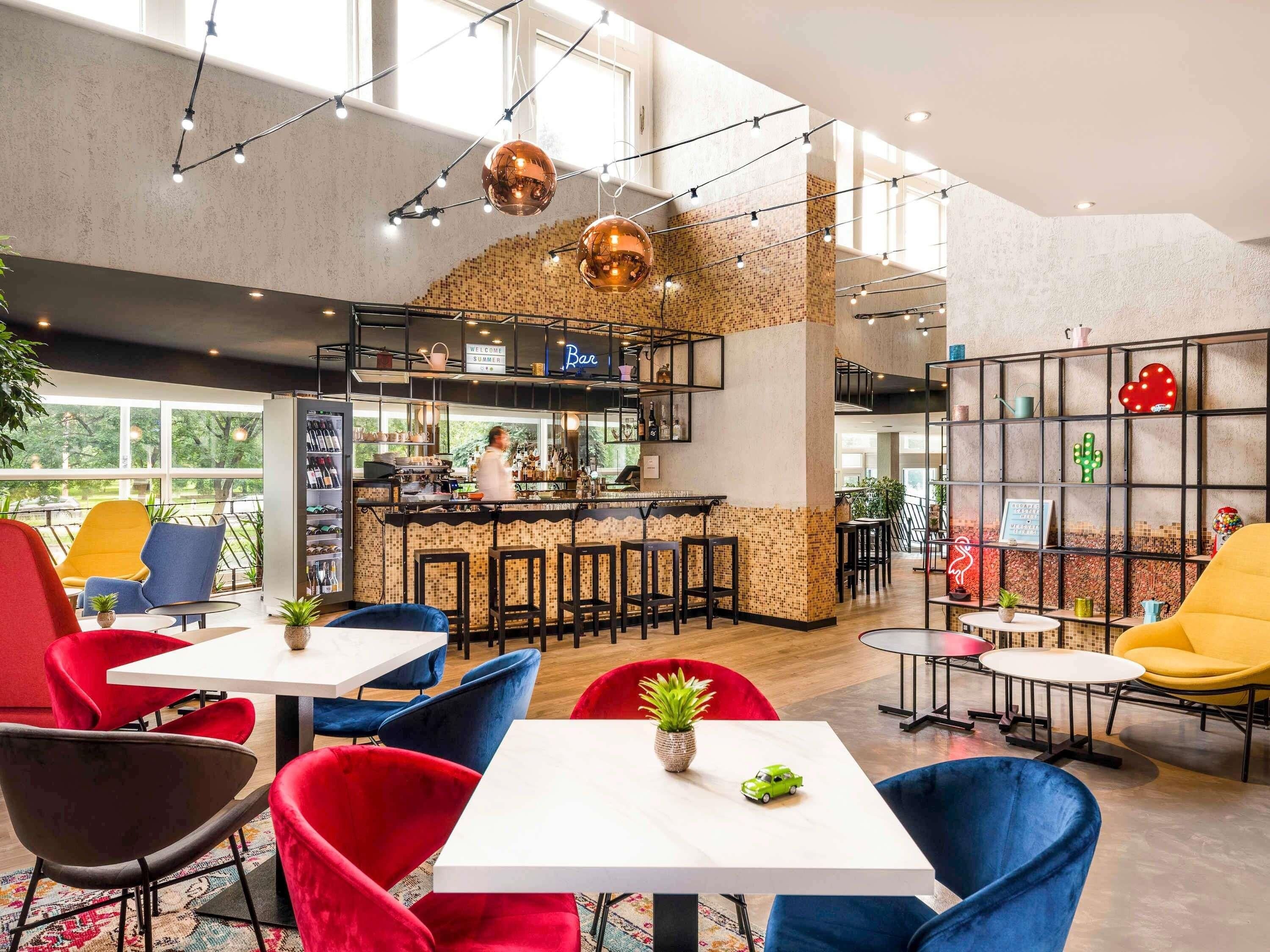 A modern bar area with a bar counter, seating, and a view of the outdoors.