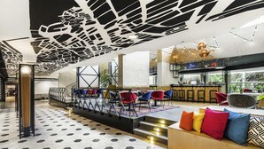 Un interior moderno con una zona de bar, asientos y una escalera.