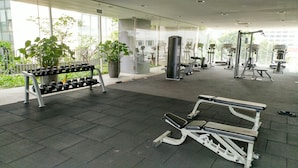 A gym with exercise equipment, a bench, and a dumbbell rack. - PJ8 Service Suite Pool View (Petaling Jaya)