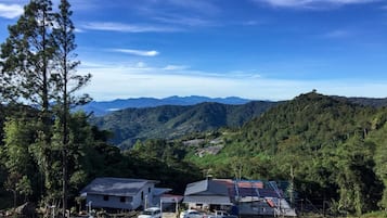 Vista de una zona montañosa con un estacionamiento, edificios y cielo despejado.