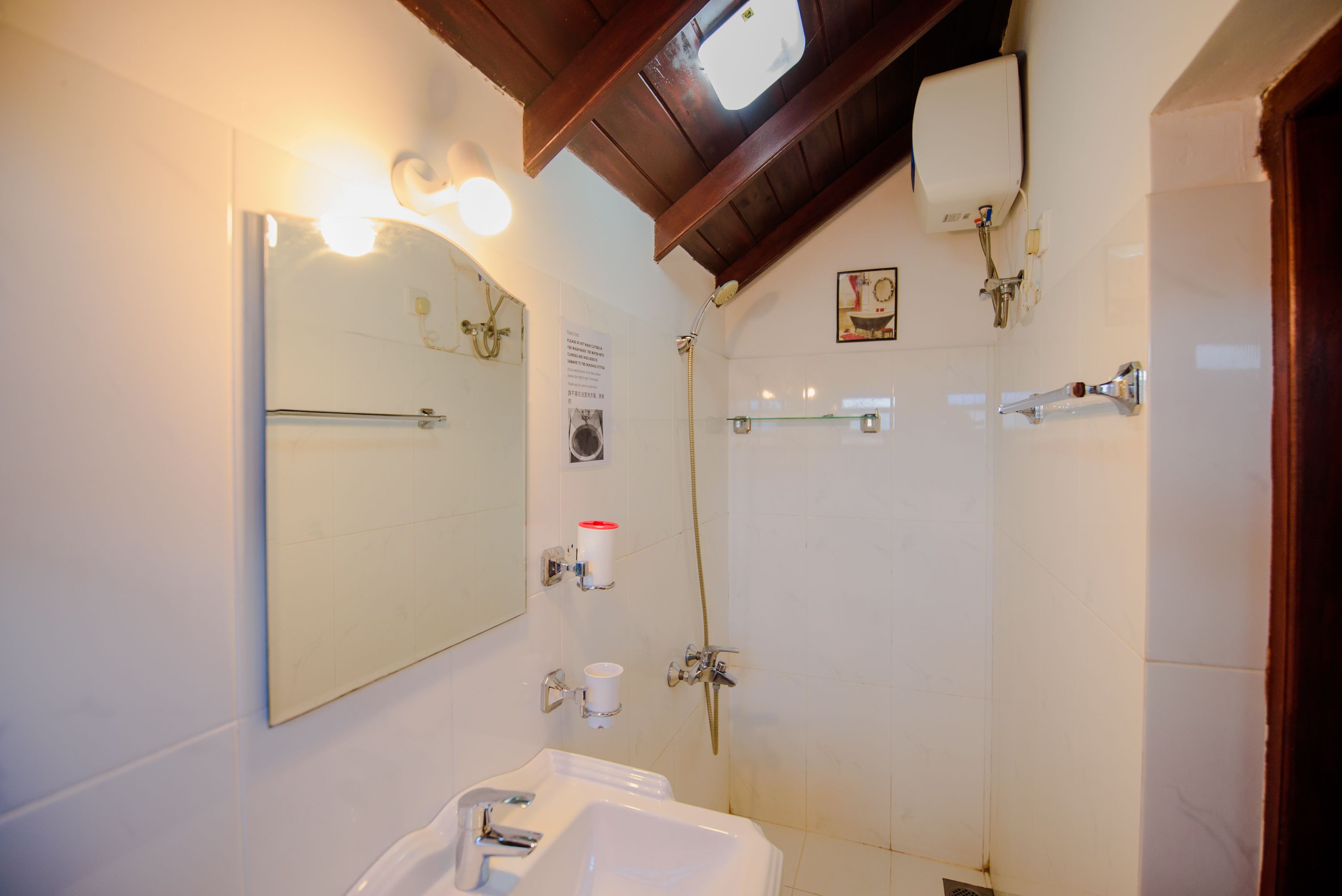 A bathroom with a sink, mirror, towel rack, and shower.