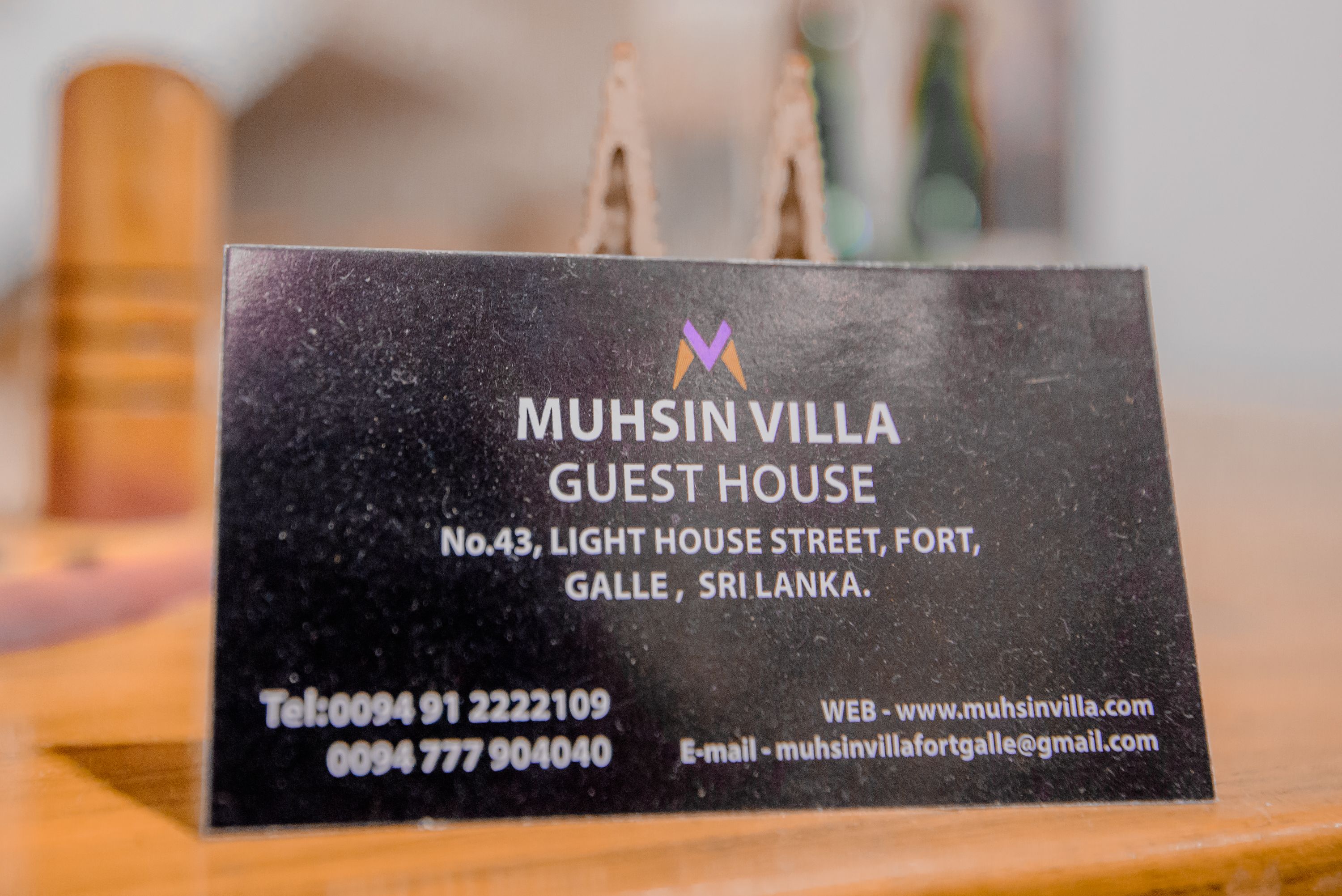 A black business card for Muhsin Villa Guest House with contact details and location in Fort, Galle, Sri Lanka.