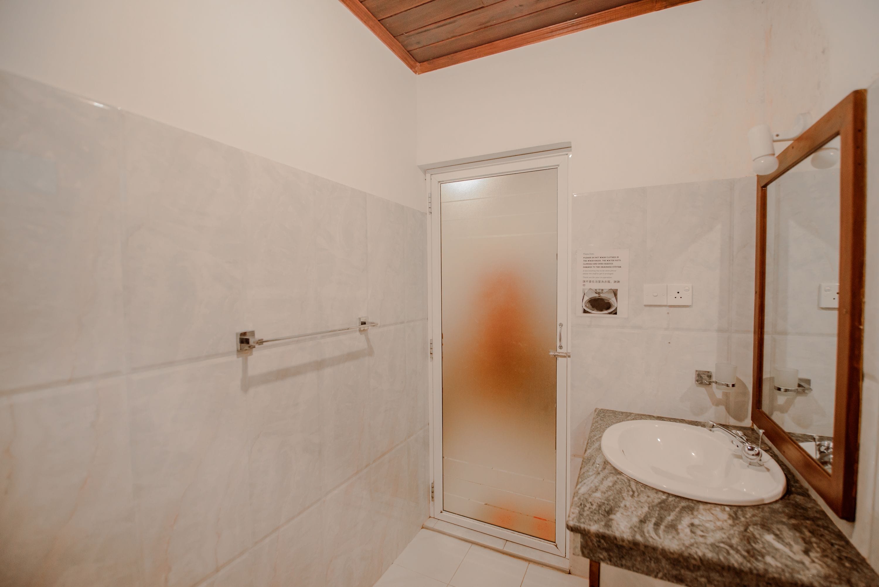 A bathroom with a shower, a sink, and a mirror.