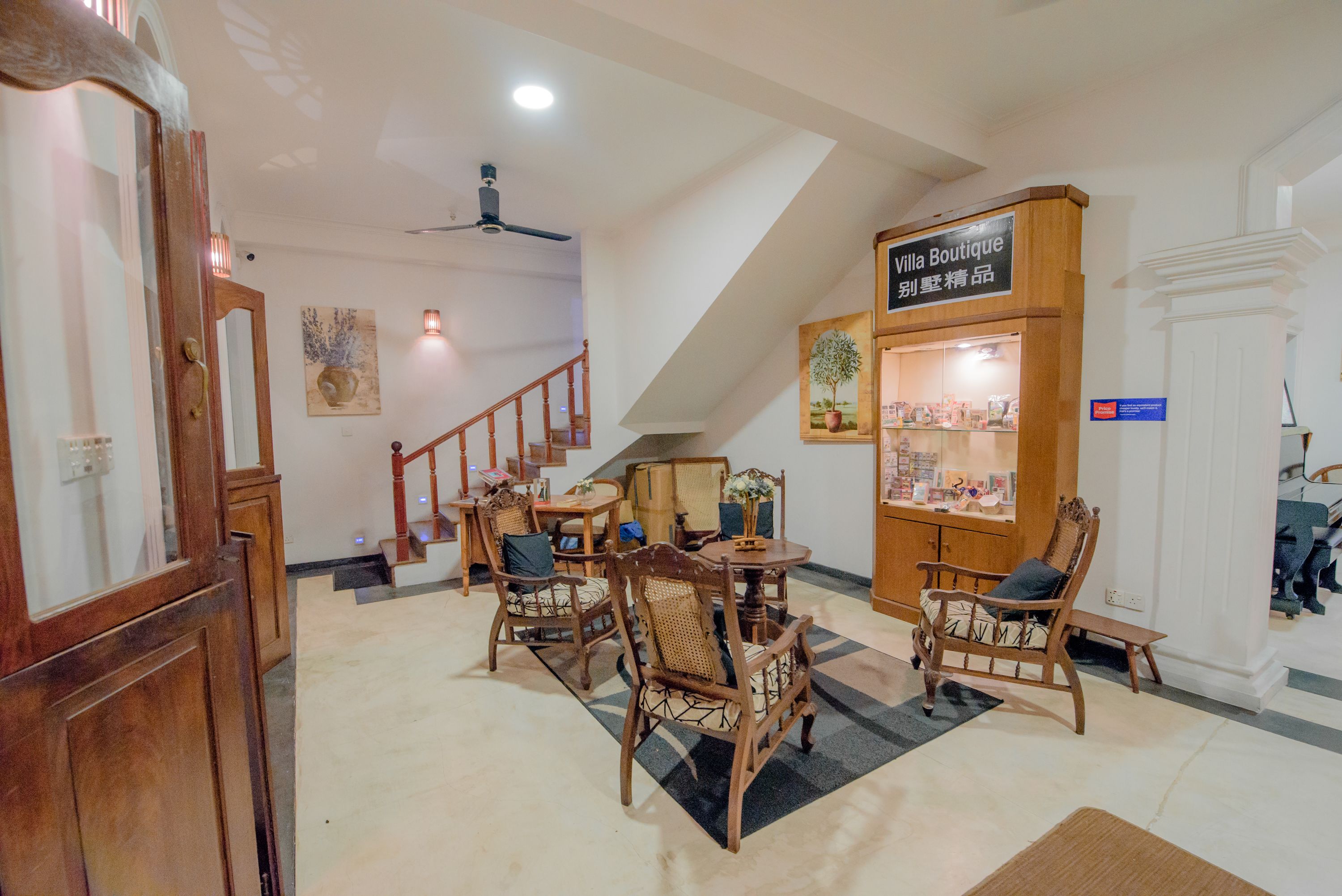 A dining area with wooden furniture, a staircase, and a boutique sign.