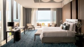 A hotel room with a large bed, a desk, a chair, and a view of the ocean. - Jumeirah Saadiyat Island Abu Dhabi (Abu Dhabi)