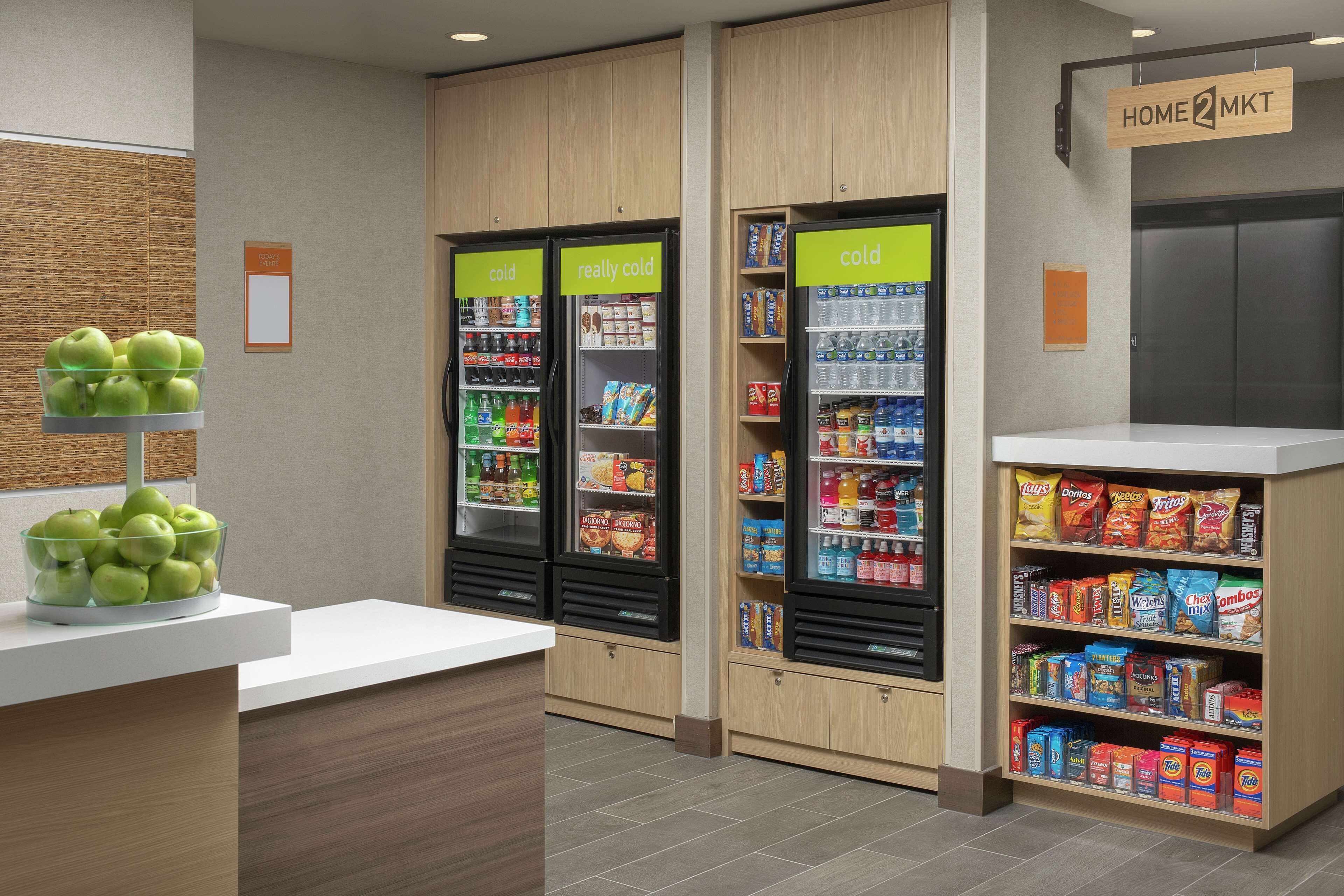 A self-service kiosk area with refrigerated sections labeled "cold" and "really cold," and a snack shelf stocked with chips and other snacks.