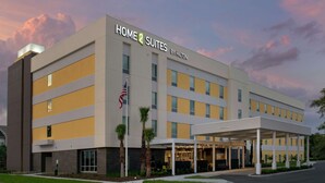Een modern hotelgebouw met een bord waarop staat 'Home 2 Suites by Hilton'.