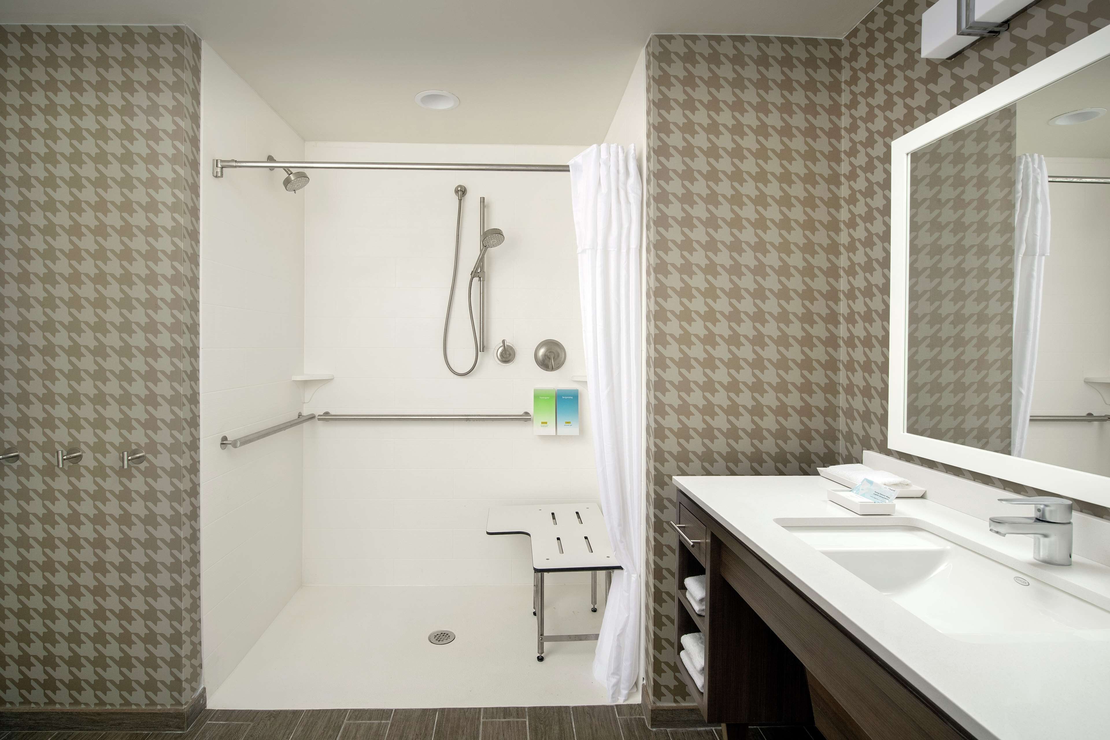 A modern bathroom with a shower, a sink, and a mirror.