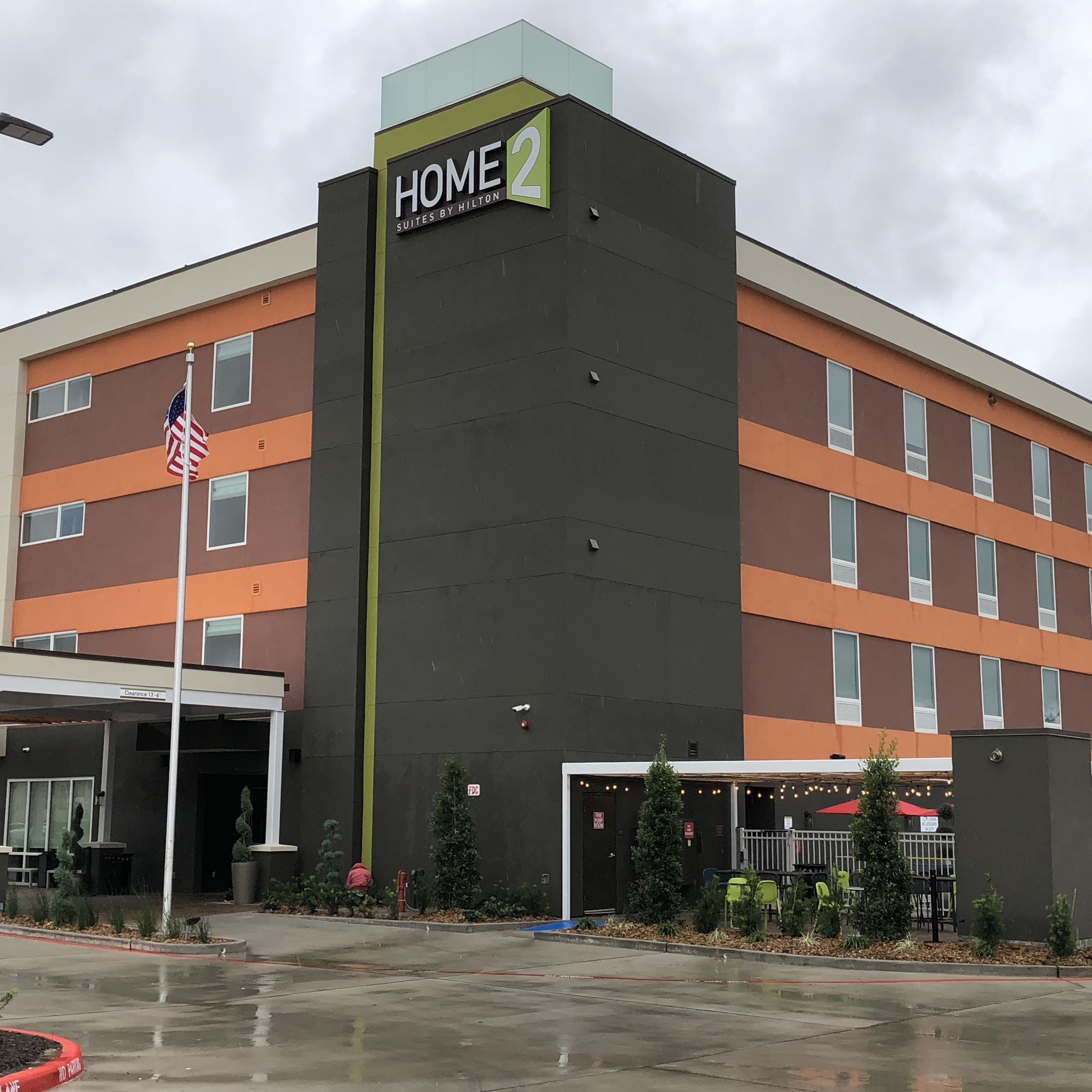 Un edificio de hotel de varios pisos con un letrero que dice 'HOME 2 Suites by Hilton'.