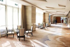 A spacious hotel lobby with a modern design, featuring a long corridor with seating areas and a large window providing natural light. - Holiday Inn Wuxi Taihu New City (Wuxi)