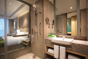 A modern hotel bathroom with a shower, sink, and mirror. - Holiday Inn Wuxi Taihu New City (Wuxi)