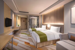 A hotel room with two beds, a sofa, a TV, and a bathroom visible through a glass door. - Holiday Inn Wuxi Taihu New City (Wuxi)