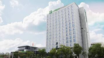 A tall, modern hotel with a prominent 'Holiday Inn' sign on the top.