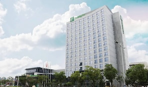 Et højt, moderne hotel med et tydeligt 'Holiday Inn' skilt øverst.