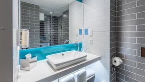 Een moderne badkamer met een wit wastafelmeubel, een blauwe accentmuur en grijze betegelde wanden.