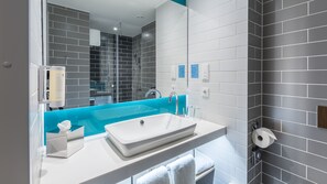 Een moderne badkamer met een wit wastafelmeubel, een blauwe accentmuur en grijze betegelde wanden.