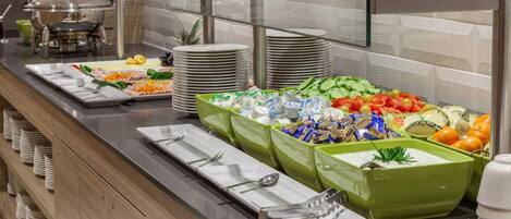 Una mesa de buffet con diferentes alimentos y utensilios.