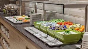 Een buffet met diverse gerechten en bestek.
