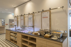 Un espace buffet avec des présentoirs clairement identifiés pour les différents plats proposés au petit-déjeuner.
