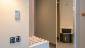A modern hotel room with a wooden bedside table, a built-in heater, and a small trash bin. - Holiday Inn Express Wuppertal - Hauptbahnhof by IHG (Wuppertal)