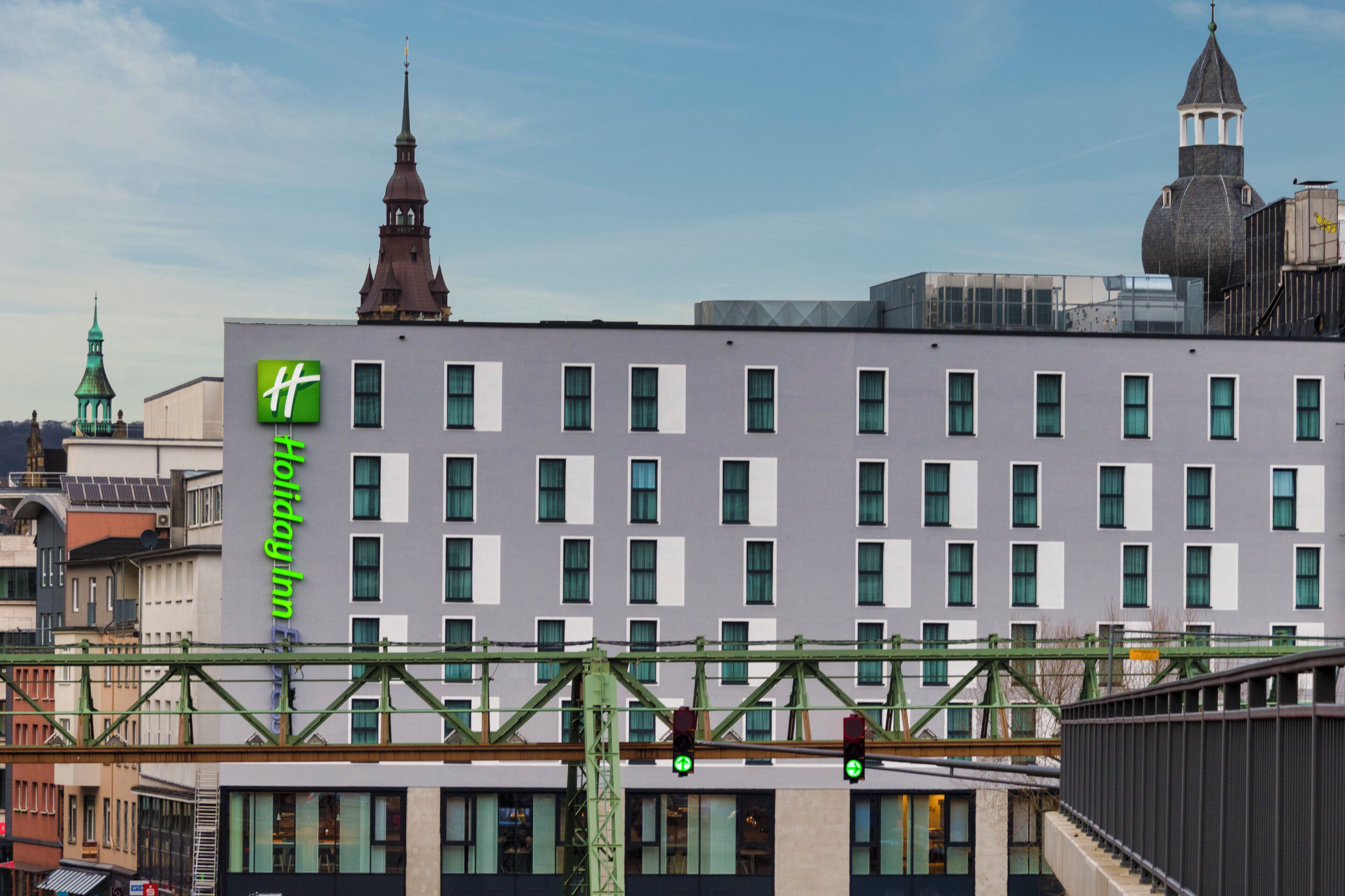 A multi-story building with a prominent green 'Holiday Inn' sign on the side.