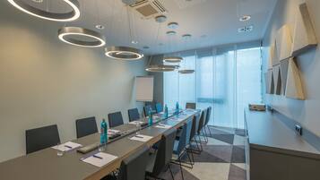 A conference room with a long table, chairs, and a whiteboard.