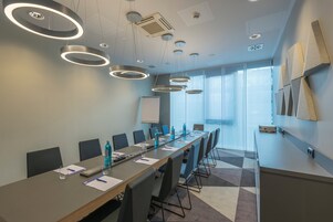 A conference room with a long table, chairs, and a whiteboard.