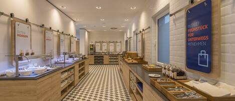 A modern breakfast area with a checkered floor, wooden counters, and breakfast stations.