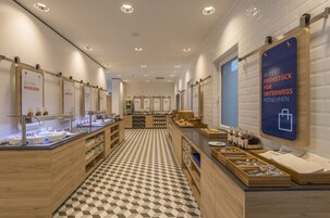 Un área de desayuno moderna con piso a cuadros, mostradores de madera y estaciones para el desayuno.