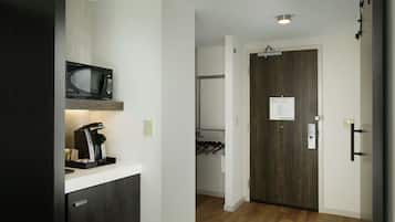 Una cocina moderna con microondas, cafetera y un mueble de madera.