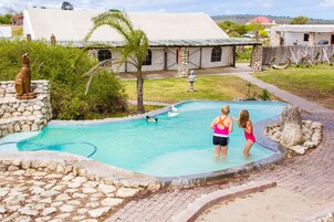 Una piscina al aire libre, sillones reclinables de piscina