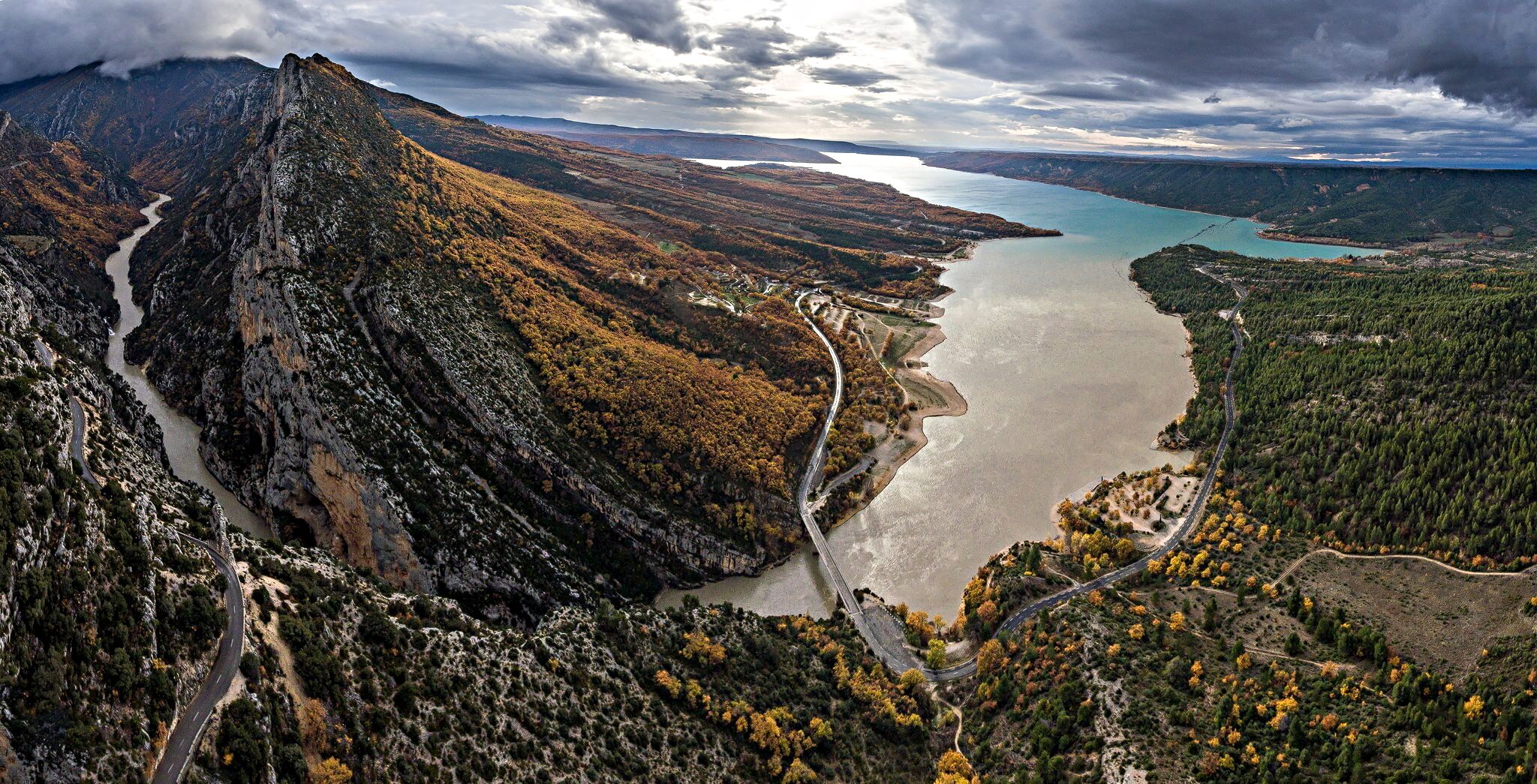 A mountainous landscape with a winding river and a lake.