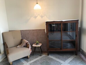 A corner room with a sofa, a small table with a plant, and a cabinet with glass doors. - La Maisonnette Tainan No.2 (Tainan)