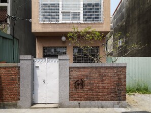A two-story building with a gated entrance, brick walls, and a metal gate. - La Maisonnette Tainan No.2 (Tainan)