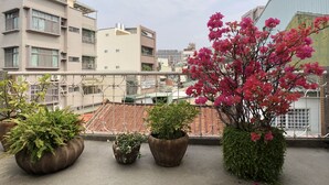 A rooftop with potted plants and a view of surrounding buildings. - La Maisonnette Tainan No.2 (Tainan)
