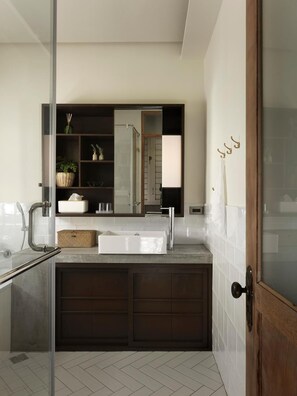 A modern bathroom with a glass shower enclosure, a large white sink, dark wooden cabinets, and a mirror above the sink. - La Maisonnette Tainan No.2 (Tainan)