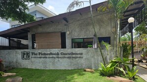 A building with a sign reading "The Picturebook Guesthouse" and a well-maintained lawn. - The Picturebook Guesthouse (Mae Sot)