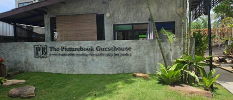 Un bâtiment sur lequel on peut lire l’inscription « The Picturebook Guesthouse », et une pelouse bien entretenue.