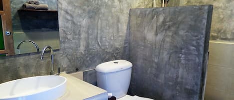 A bathroom with a white sink, a toilet, and a hand dryer.