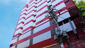 Um edifício alto e vermelho com uma placa que diz 'Hotel 1000 So Clean... So Good!' e um endereço de site.
