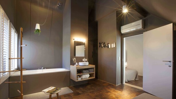 A modern bathroom with a freestanding bathtub, a vanity with a mirror, and a towel rack. - Hotel Restaurant Vous lé Vous (Hasselt)