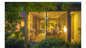 A modern building with large windows and a visible interior space. - Hotel Restaurant Vous lé Vous (Hasselt)