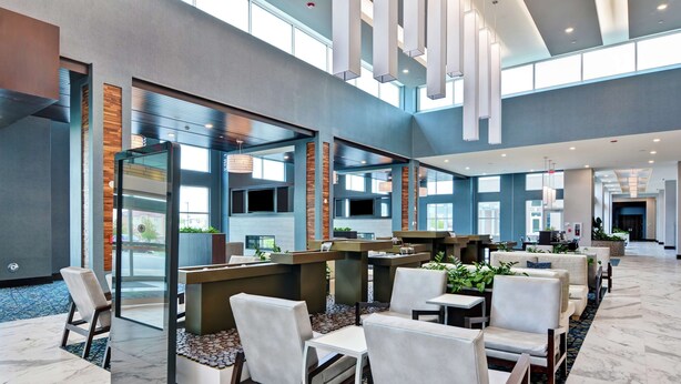 A spacious lobby with high ceilings, modern seating arrangements, and large windows allowing natural light.